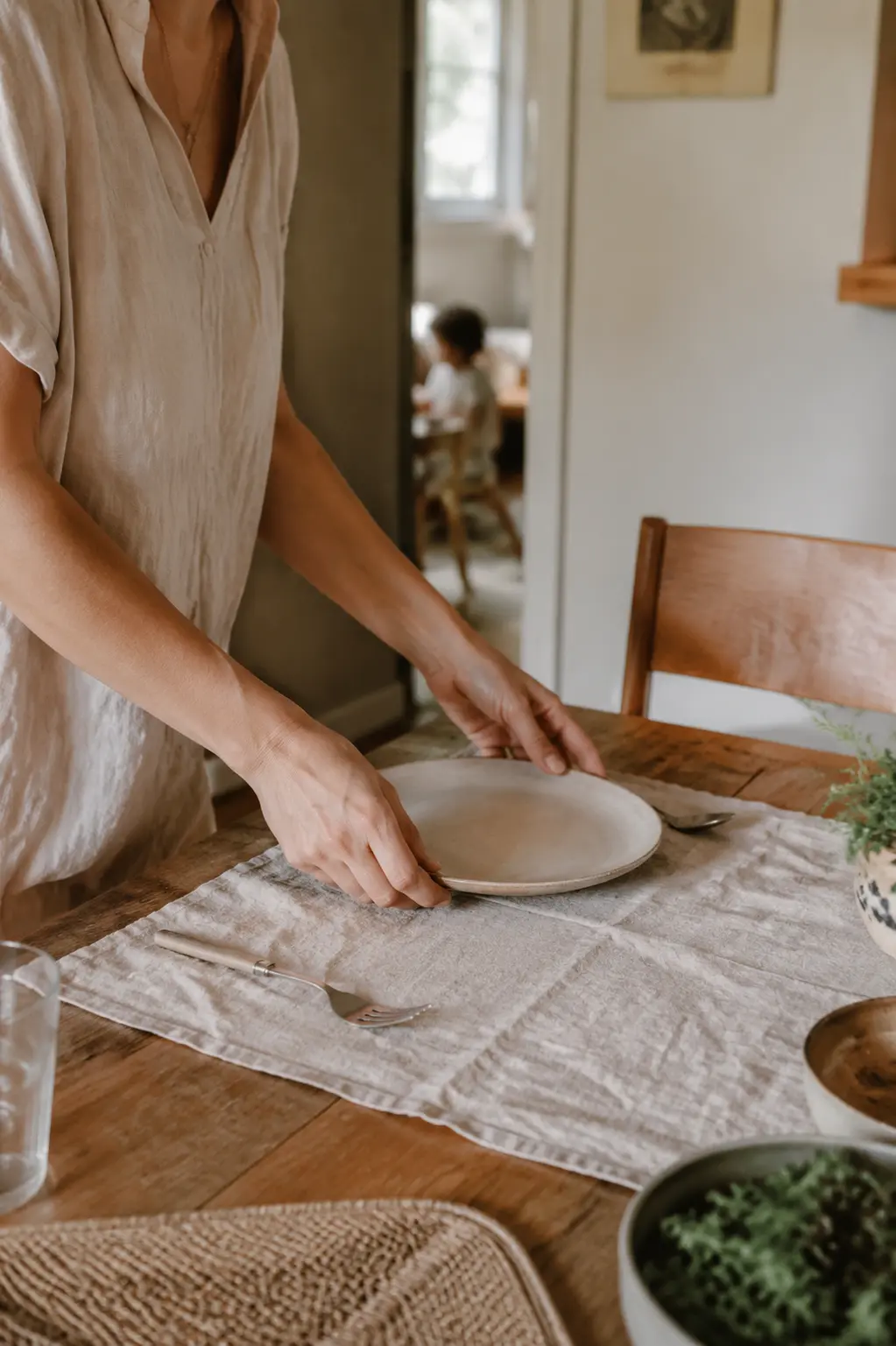 Mãos preparando uma mesa para a vida em família.
